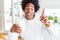 African American man holding and drinking glass of milk surprised with an idea or question pointing finger with happy face, number