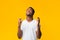 African American Man Keeping Fingers Crossed Standing Over Yellow Background