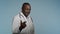 African American man in medical gown walking in gray background studio male doctor hospital employee invites patients to