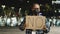 African american man in medical mask stands in evening night city holding sign banner cardboard text no, angry guy