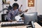 African american man musician composing song playing electrical guitar at music studio