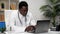 African American man online doctor talking to patient video call webcam laptop