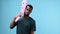 African american man plays with an inflatable pink bat in his hands, beats himself on the head, dances carelessly in a t