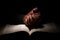 African American Man Praying with Hands on Top of the Bible