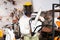 African-american man in protective helmet and with chainsaw in hands in gardening tools shop.