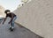 African american man riding longboard on the road with palm trees in the background - Focus on face