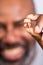 African American Man showing extracted tooth. Senior man happily holding pulled tooth.  Selected Focus with Blurred background