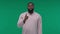 African American man showing hush gesture isolated on Green Screen, Chroma Key background, keeping finger on lips