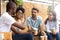 African American man showing thumb up to friends in cafe