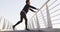 African american man stretching, leaning on footbridge exercising outdoors