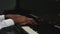 An African American man with two hands plays gentle classical music on the grand piano. Close up professional pianist`s