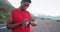 African american man using fitness band while standing on the road