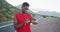 African american man using fitness band while standing on the road