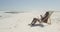 African american man using his laptop at beach and drinking juice