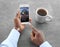 African-American man using weather forecast app on smartphone at table