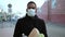 African american man wearing protective mask carrying paper bag with groceries, coming back from shopping