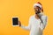 African American man in winter sweater and Santa hat holding digital tablet