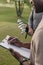 African american man writing something on paper in clipboard while standing on golf course