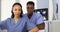 African American medical specialists sitting in front of computer