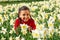 African American mixed race girl sitting playing laughing in a field of daffodils