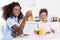 african american mother and daughter having breakfast with pancakes and orange juice