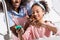 african american mother and daughter having fun while washing dishes with sponge