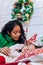 African American mother puts daughter to sleep on Christmas