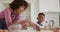 African american mother and son in kitchen cooking, cutting dough