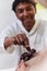 African American Muslim man delicately takes dates to break his fast during the Ramadan month, seated at the family