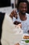 African American Muslim man delicately takes dates to break his fast during the Ramadan month, seated at the family