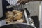 African American Nigerian man grilling roasting chicken thighs on Barbeque