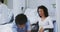 African American nurse assists a biracial woman in a hospital room