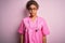 African american nurse girl wearing medical uniform and stethoscope over pink background puffing cheeks with funny face