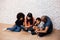 African American parents reading a fairy tale fable story for kids at home. Happy family sitting on the floor indoors.