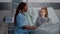 African american pediatrician nurse sitting beside sick child giving high five