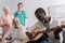 African american pensioner playing acoustic guitar