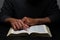 African American Person Studying the Bible in Dark Room