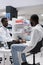 African american pharmacist measuring patient blood sugar with glucometer