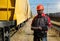 African american railway man with tablet computer at freight train terminal