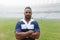 African american rugby player standing with arms crossed in the stadium