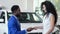 African American salesman gives key to bought car to client