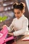 African american schoolgirl packing backpack and preparing for school