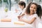 African american schoolgirl smiling at camera while classmate studying behind in class