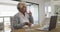 African american senior woman medicine in front of laptop at home