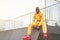 African-american smiling black man yellow hoodie outside Happy emotional afro model guy sitting skate park summer day Free space