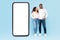 African american spouses standing near huge mobile phone with empty screen, posing over blue background, mockup