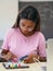 African American student teen girl experimenting with electronic circuits in technology class