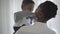 African american stylish woman in white blouse taking on hands her funny playful child boy in cozy living room