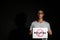 African-American teenage boy holding sheet of paper with word STOP on dark background