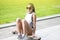 African American Teenage Girl with Dreadlocks Posing on Longboard Skate Outdoors